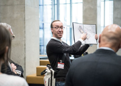 Met behulp van het beeldboek vertelt de gids over het concept, de architectuur en historie van het gebouw en de Wilhelminapier.