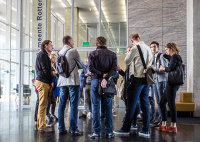 De gids staat met tourgroep in de lobby van het gebouw De Rotterdam.