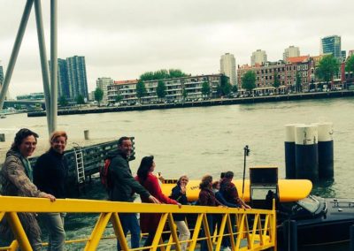 Passagiers lopen over het steiger naar de watertaxi om naar de Boompjes te varen.